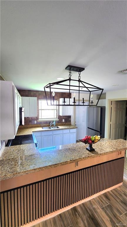 Kitchen with freestanding refrigerator, wood finished floors, and range with electric stovetop