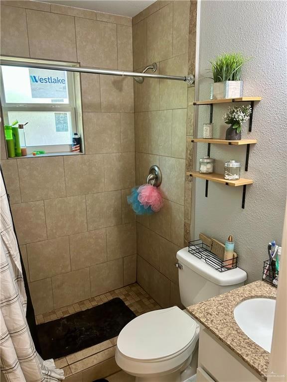 Bathroom with a textured wall, a shower stall, and vanity