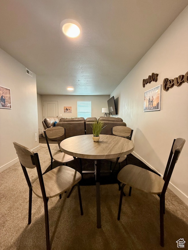 Carpeted dining area with baseboards