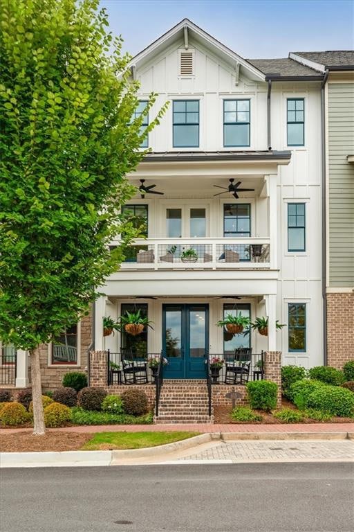 View of front of property with french doors, covered porch, board and batten siding, and brick siding