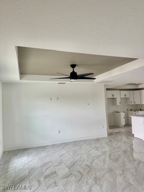 Unfurnished room featuring a tray ceiling, a ceili