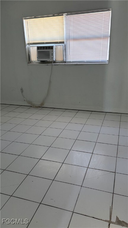 Spare room with light tile patterned flooring and cooling unit