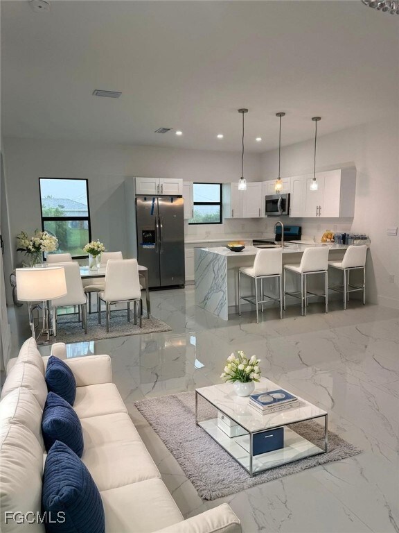 Living room with recessed lighting and light marble finish flooring