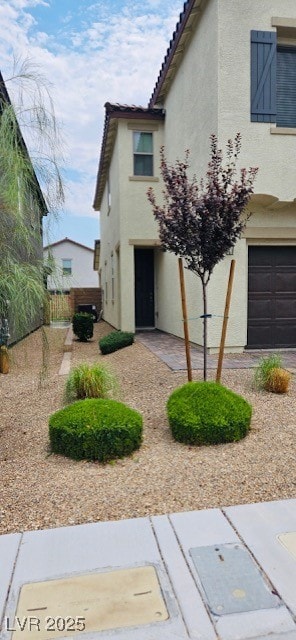 View of front of property with stucco siding, a ti