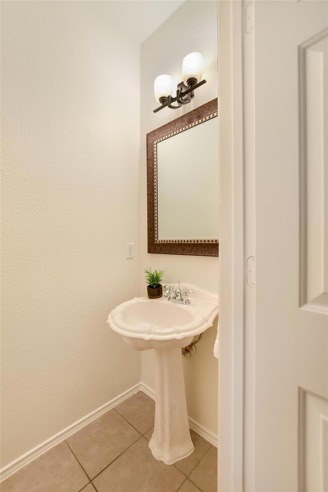 Bathroom with tile patterned floors and baseboards