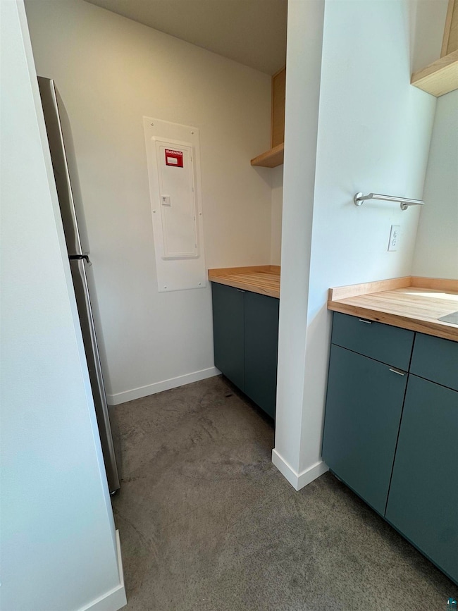 Laundry room featuring dark carpet and electric panel