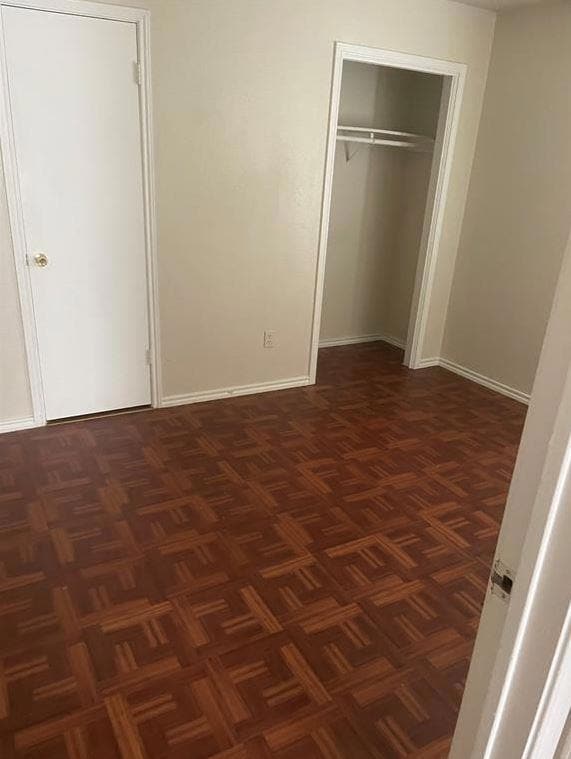 Unfurnished bedroom with a closet and baseboards