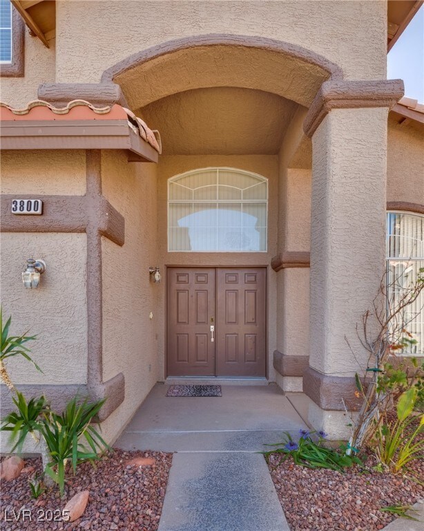 View of exterior entry featuring stucco siding