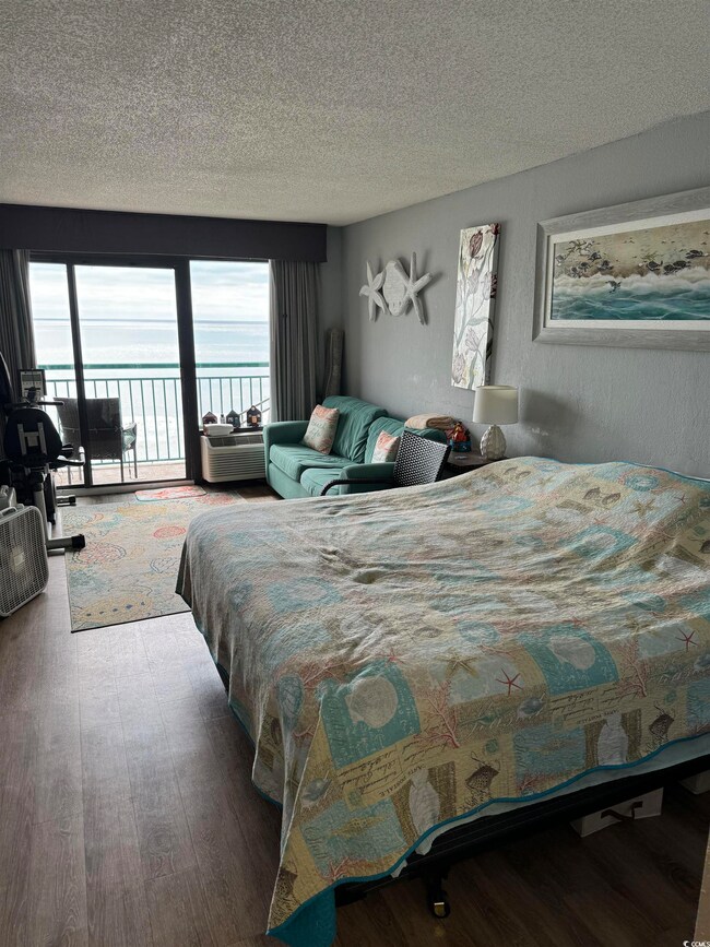 Bedroom featuring a water view, a textured ceiling