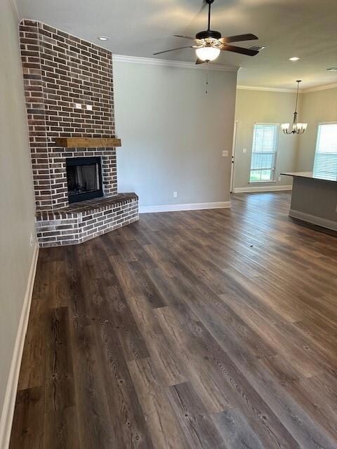 Unfurnished living room with ornamental molding, a fireplace, and dark wood-type flooring