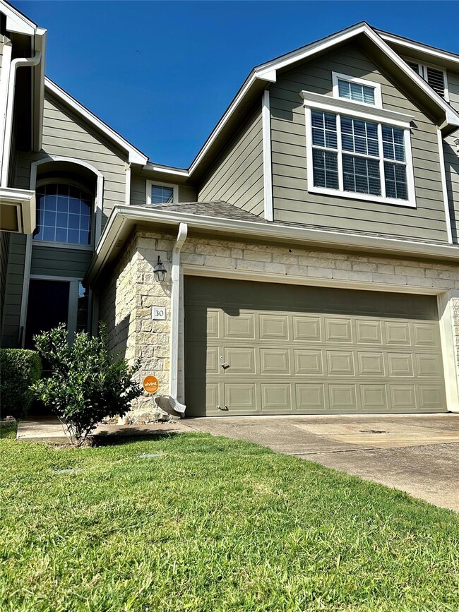 View of property exterior featuring a lawn, an at