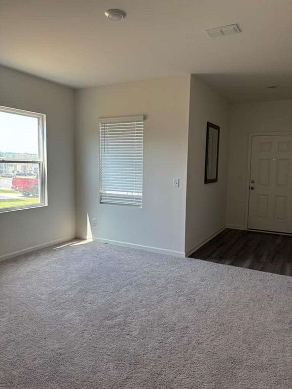 Empty room featuring dark carpet