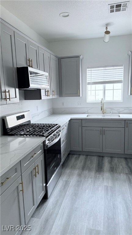 Kitchen featuring gray cabinets, appliances with s