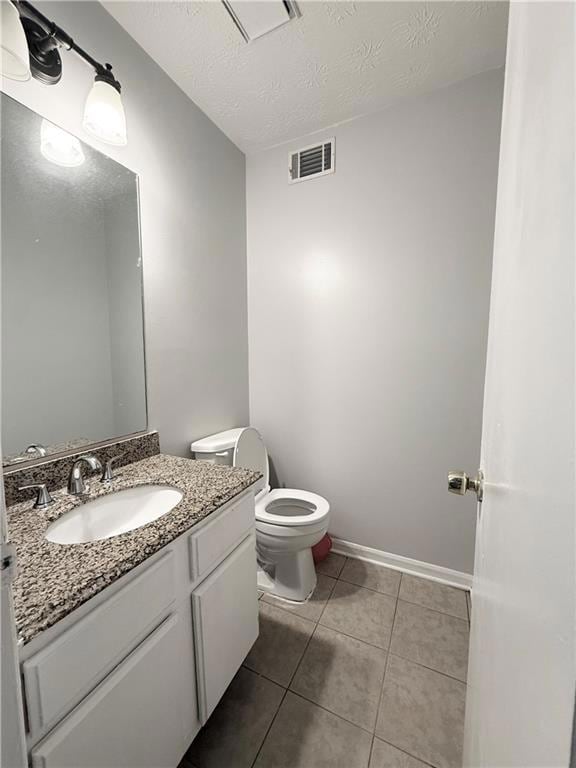 Half bath featuring vanity, tile patterned flooring, and a textured ceiling