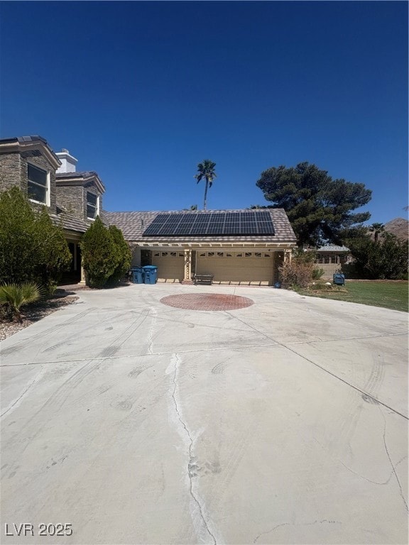 View of front facade with a garage, solar panels,