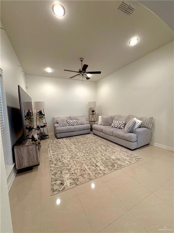 Living room featuring ceiling fan and light tile patterned flooring