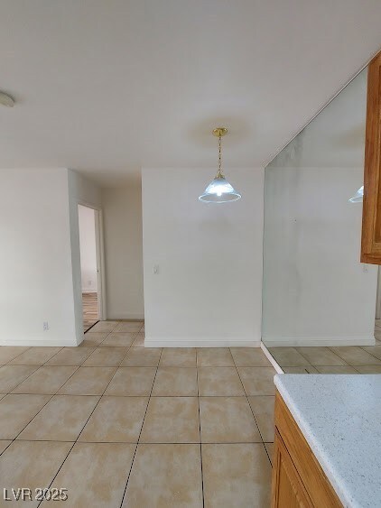 Unfurnished dining area featuring light tile patte