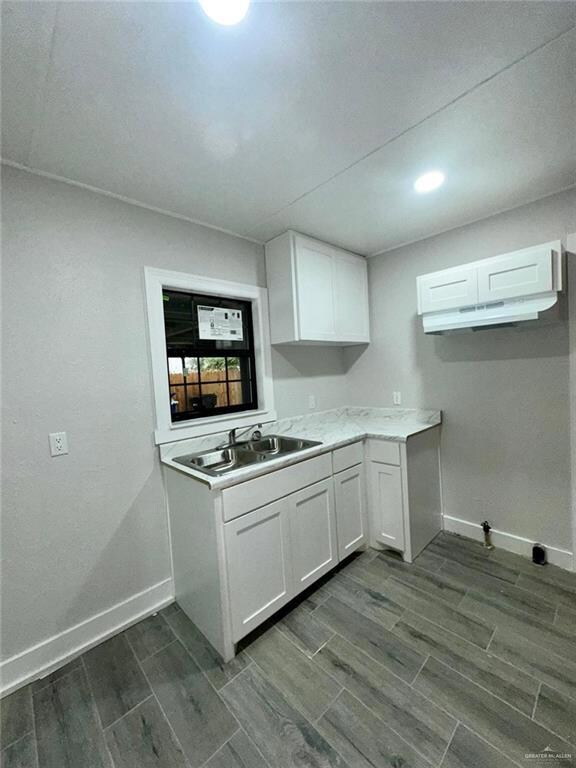 Kitchen with white cabinets, dark hardwood / wood-style flooring, and sink