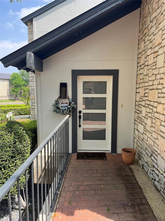 Entrance to property with stucco siding and stone