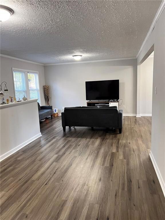 Living room featuring a textured ceiling, crown mo