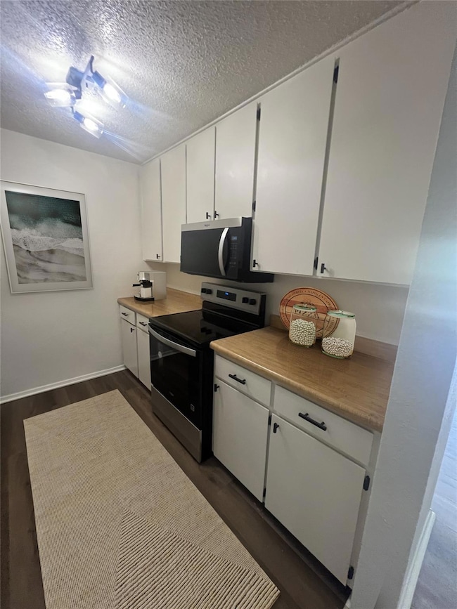 Kitchen with dark wood-type flooring, white cabine