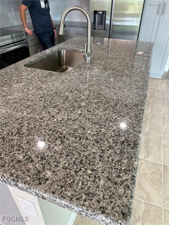 Kitchen view of stainless steel refrigerator with
