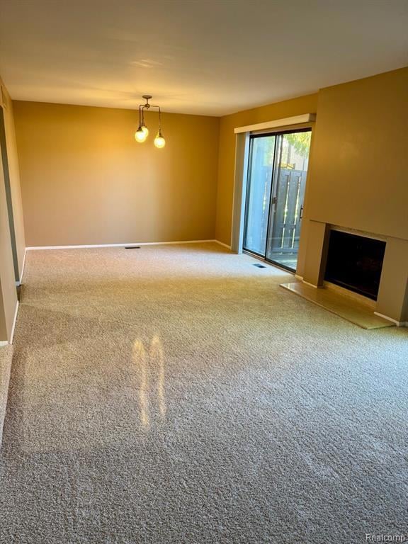 Unfurnished living room featuring a fireplace and carpet floors