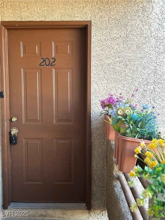 Property entrance featuring stucco siding