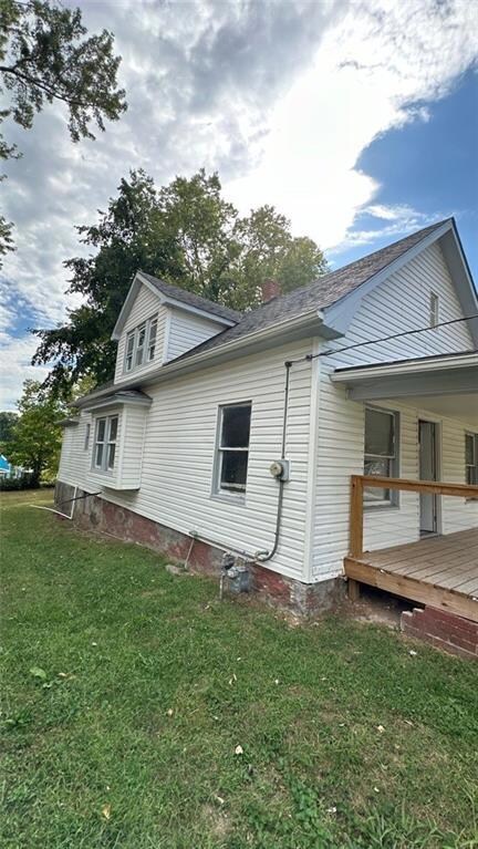 View of home's exterior with a wooden deck and a yard