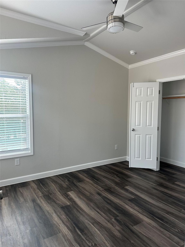 Unfurnished bedroom featuring crown molding, dark