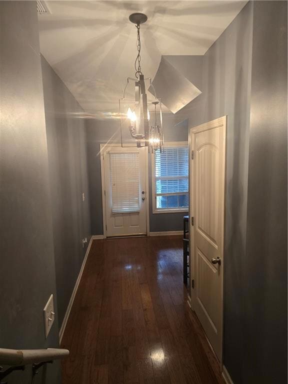 Doorway to outside featuring baseboards, an inviti