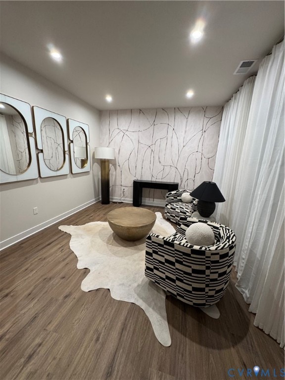Living area featuring recessed lighting, wood finished floors, a fireplace, and an accent wall