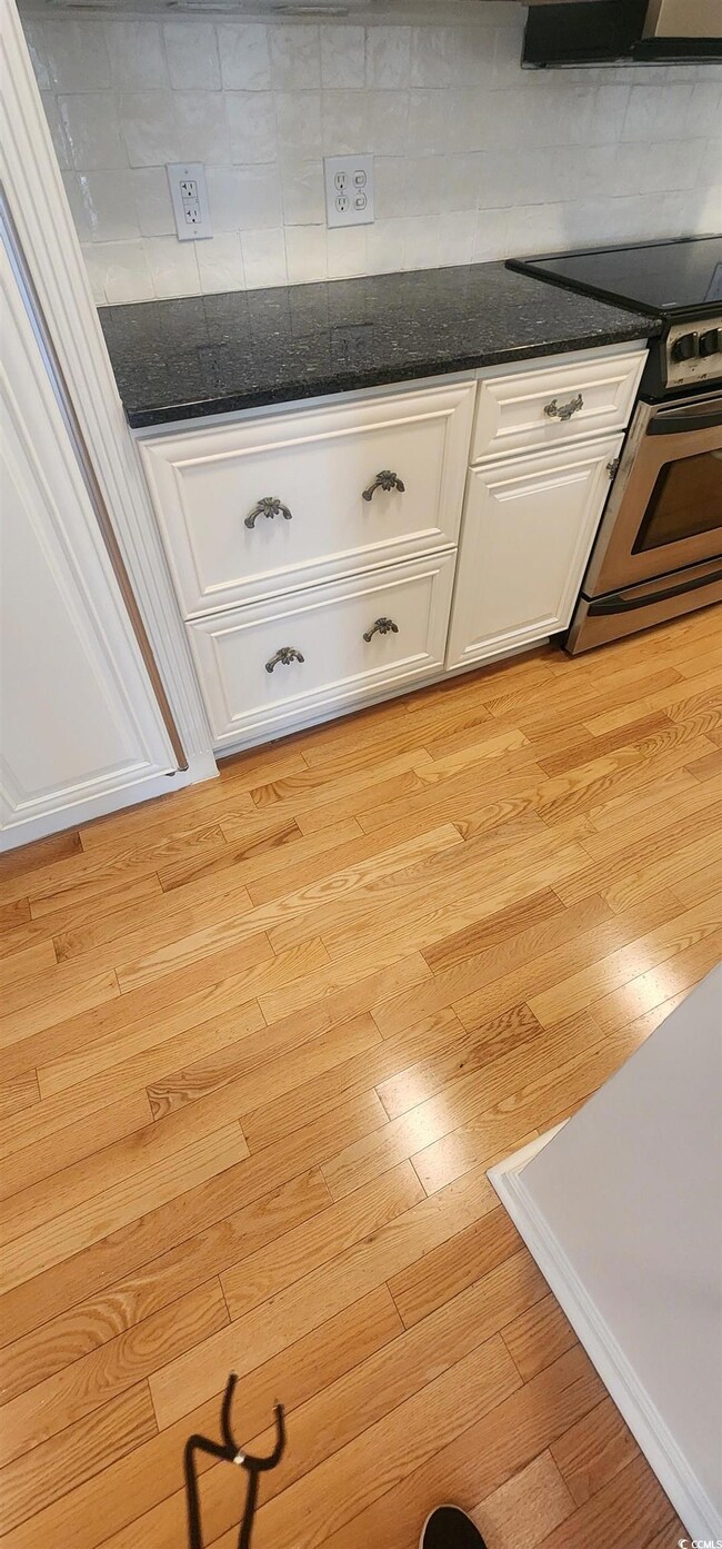 Room details with white cabinetry, dark stone coun