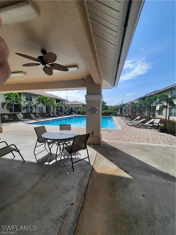 Pool with fence, ceiling fan, and a patio