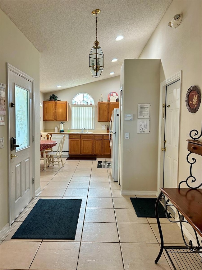 Foyer Facing Kitchen with vaulted ceiling and plenty of natural and recessed lighting.