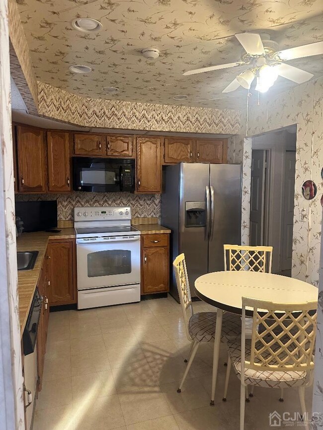 Eat-in kitchen with new stainless steel refrigerator.
