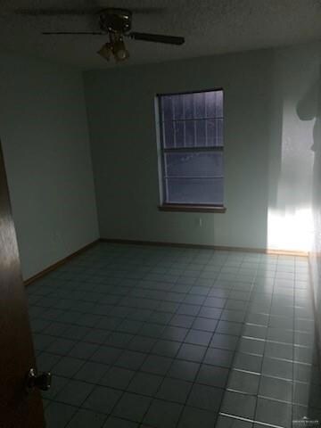 Tiled spare room with ceiling fan