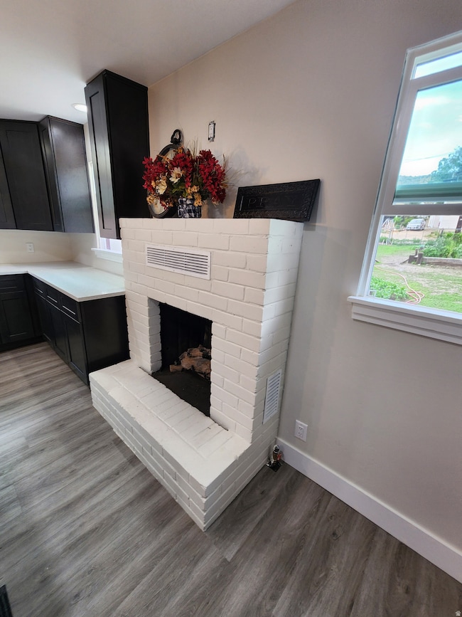 Detailed view of wood finished floors and a fireplace