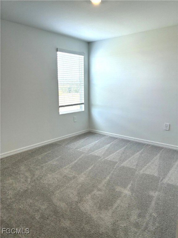 Empty room featuring carpet floors and baseboards