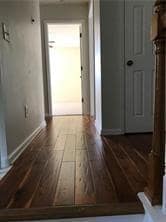 Hall with dark wood-style floors and baseboards