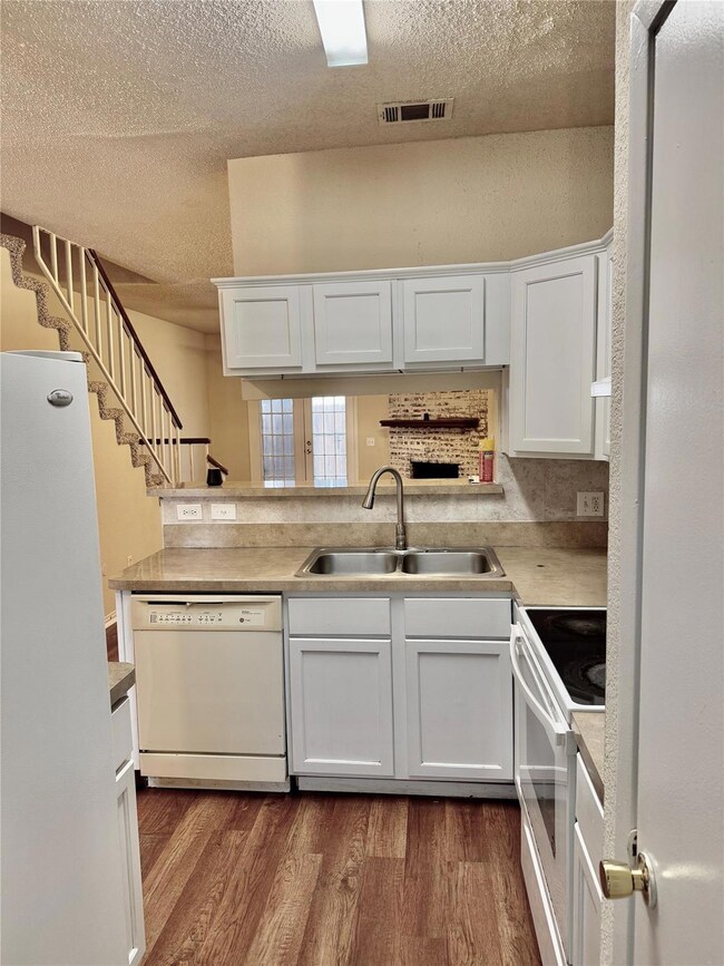 Kitchen featuring white appliances, visible vents,