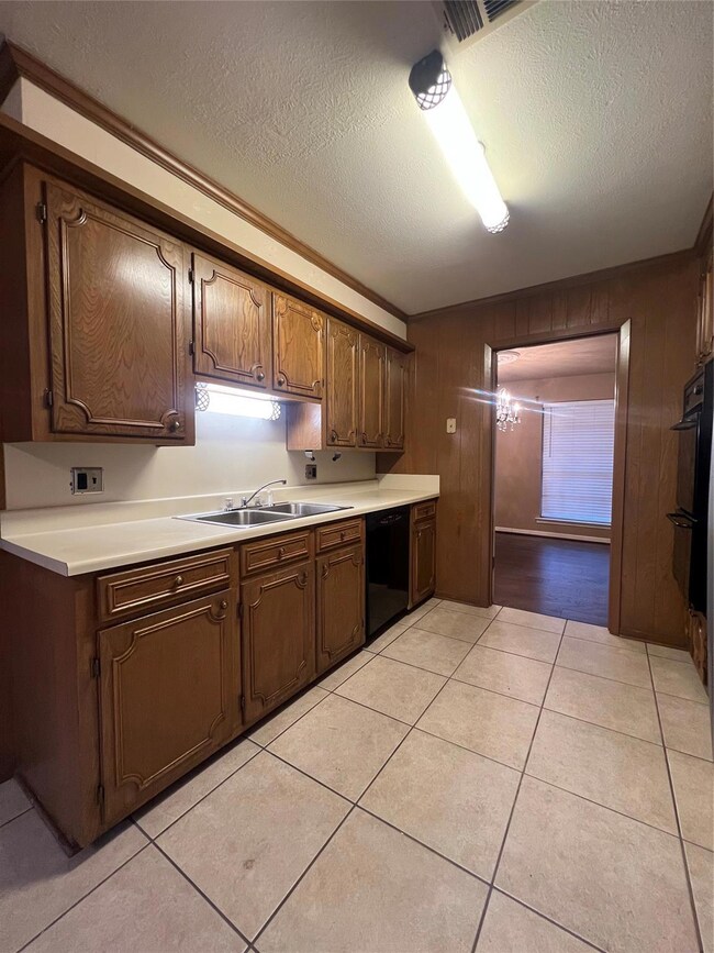 Kitchen with dishwasher, crown molding, a textured