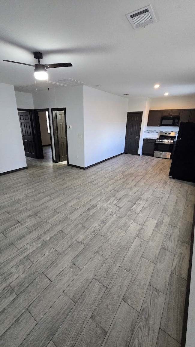 Living area with open floor plan and fan ceiling.