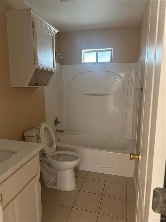 Full bath with toilet, bathing tub / shower combination, vanity, and tile patterned floors