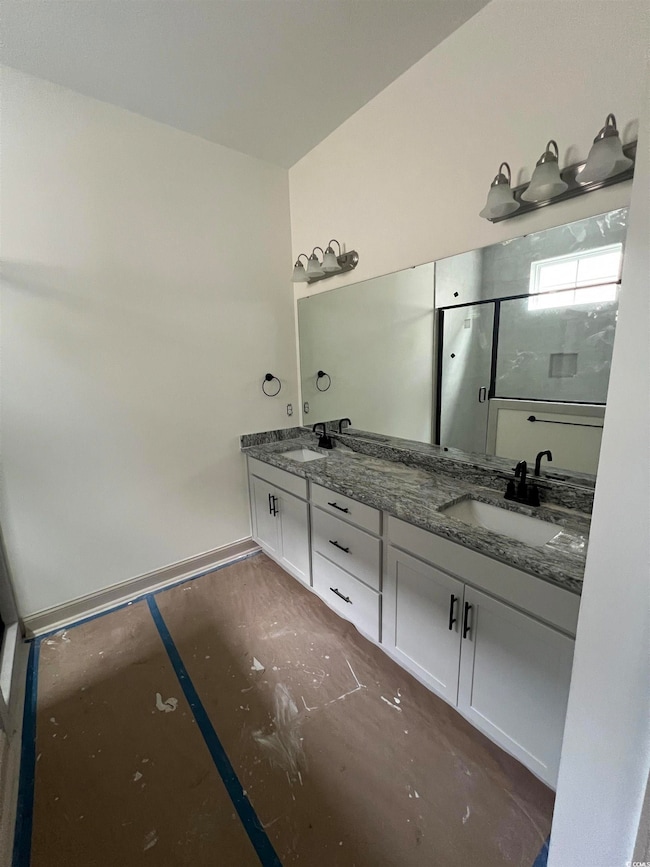 Full bathroom featuring double vanity and a stall shower
