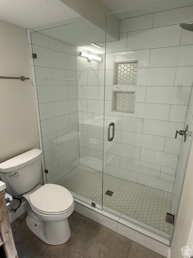 Bathroom featuring a stall shower, vanity, tile patterned floors, and a textured ceiling