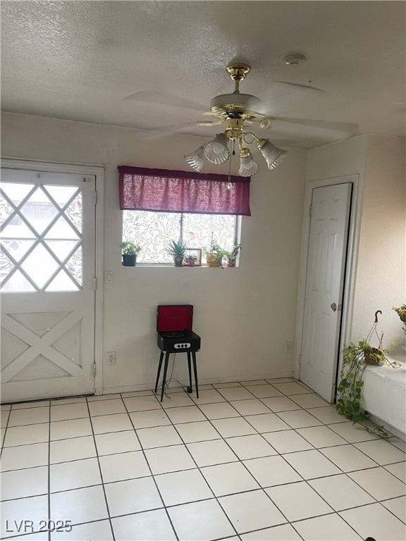 Foyer entrance with ceiling fan, a textured ceilin