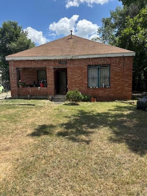 Back of property featuring a lawn
