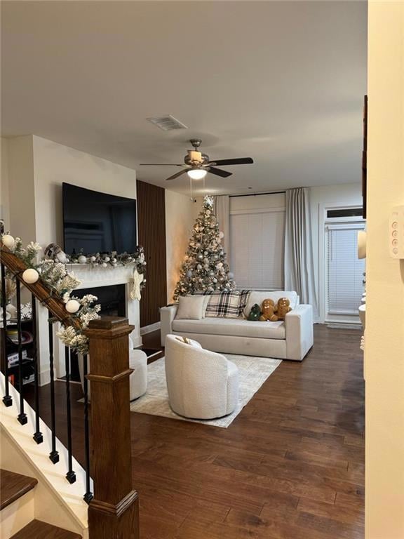 Living room featuring ceiling fan and dark wood-ty