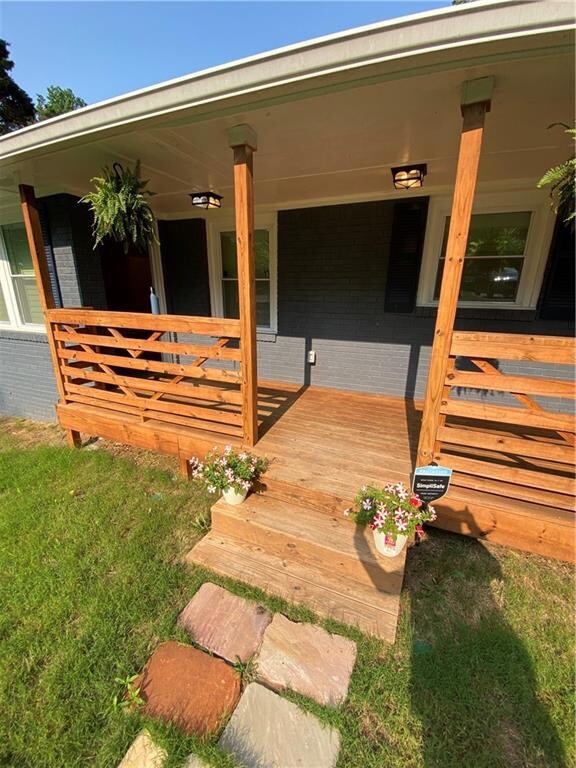 Property entrance featuring brick siding and a porch
